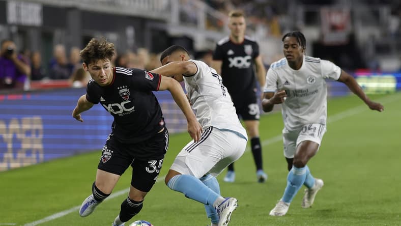 Apr 23, 2022; Washington, District of Columbia, USA;  D.C. United midfielder Theodore Ku-DiPietro (35) dribbles the ball as New England Revolution midfielder Damian Rivera (72) defends in the second half at Audi Field. Mandatory Credit: Geoff Burke-USA TODAY Sports