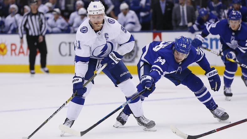 Apr 4, 2019; Toronto, Ontario, CAN; Tampa Bay Lightning forward Steven Stamkos (91) moves the puck against Toronto Maple Leafs forward Auston Matthews (34) at Scotiabank Arena. Tampa Bay defeated Toronto. Mandatory Credit: John E. Sokolowski-USA TODAY Sports