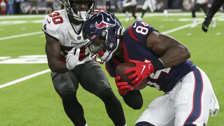 Aug 28, 2021; Houston, Texas, USA; Houston Texans wide receiver Jordan Veasy (84) runs with the ball after a reception as Tampa Bay Buccaneers defensive back Dee Delaney (30) attempts to make a tackle during the fourth quarter at NRG Stadium. Mandatory Credit: Troy Taormina-USA TODAY Sports