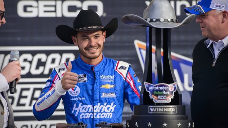 Oct 17, 2021; Fort Worth, Texas, USA; NASCAR Cup Series driver Kyle Larson (5) poses with the trophy in victory lane after he wins the Autotrader EchoPark Automotive 500 in the NASCAR round of 8 opening race at Texas Motor Speedway. Mandatory Credit: Jerome Miron-USA TODAY Sports
