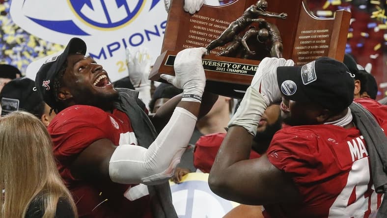 Dec 4, 2021; Atlanta, GA, USA; Alabama Crimson Tide linebacker Will Anderson Jr. (31) and defensive lineman Phidarian Mathis (48) hoist the trophy after defeating the Georgia Bulldogs in the SEC championship game at Mercedes-Benz Stadium. Alabama won 41-24. Mandatory Credit: Gary Cosby Jr.-USA TODAY Sports