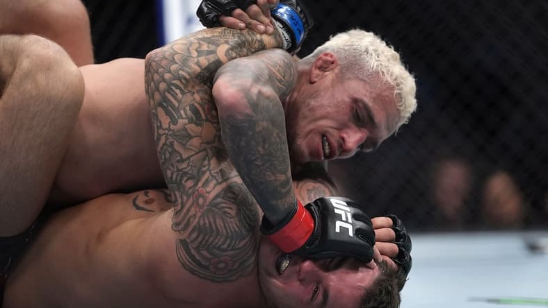 Dec 11, 2021; Las Vegas, Nevada, USA; Charles Oliveira pins Dustin Poirier to the mat during UFC 269 at T-Mobile Arena. Mandatory Credit: Stephen R. Sylvanie-USA TODAY Sports