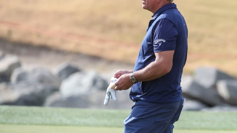 Phil Mickelson gives advice to an amateur in his group while playing the 11th green of the Pete Dye Stadium course during the third round of The American Express at PGA West in La Quinta, Calif., Saturday, Jan. 22, 2022.