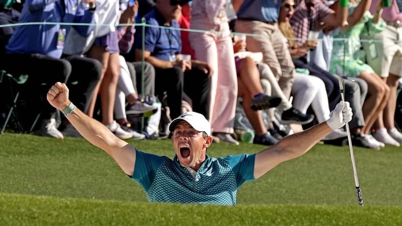 Apr 10, 2022; Augusta, Georgia, USA; Rory McIlroy celebrates after holing out from a bunker on the 18th hole during the final round of the Masters golf tournament. Mandatory Credit: Michael Madrid-USA TODAY Sports
