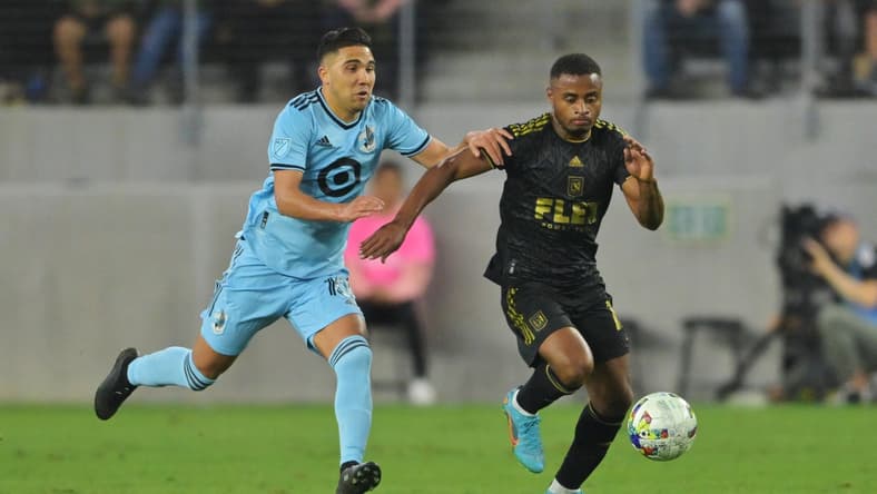 May 1, 2022; Los Angeles, California, USA; Minnesota United midfielder Emanuel Reynoso (10) chases Los Angeles FC defender Diego Palacios (12) during the first half at Banc of California Stadium. Mandatory Credit: Jayne Kamin-Oncea-USA TODAY Sports