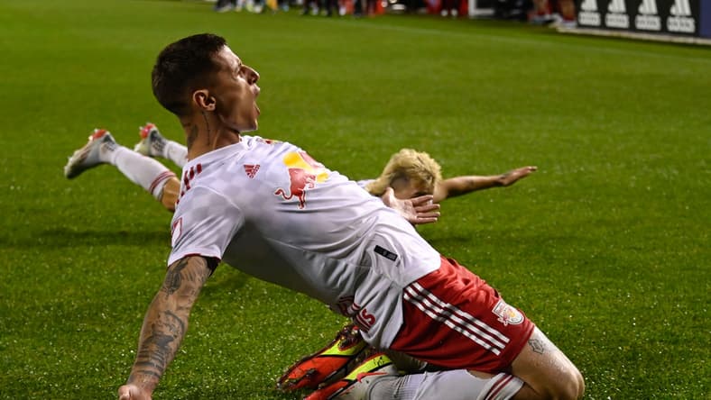 Apr 30, 2022; Chicago, Illinois, USA; New York Red Bulls forward Patryk Klimala (9), left, and New York Red Bulls defender John Tolkin (47) slide on the field after Klimala scored a goal during the second half against the Chicago Fire at Soldier Field. Mandatory Credit: Matt Marton-USA TODAY Sports