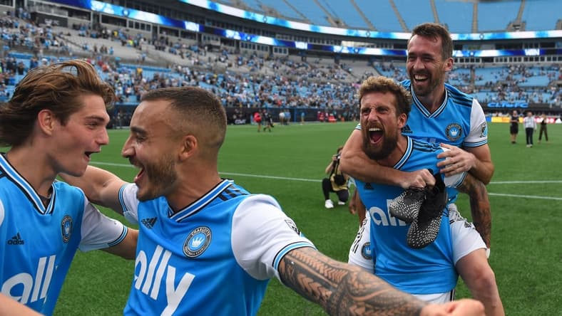 May 7, 2022; Charlotte, North Carolina, USA; Charlotte FC attacker Andre Shinyashiki (16) celebrates with midfielder Benjamin Bender (15) and defender Guzman Corujo (4) and defender Christian Fuchs (22) after the match at Bank of America Stadium. Mandatory Credit: Bob Donnan-USA TODAY Sports