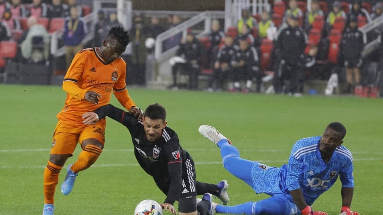 May 7, 2022; Washington, District of Columbia, USA; Houston Dynamo forward Carlos Darwin Quintero (23) dribbles the ball past D.C. United defender Brendan Hines-Ike (4) as D.C. United goalkeeper Bill Hamid (28) chases in the first half at Audi Field. Mandatory Credit: Geoff Burke-USA TODAY Sports