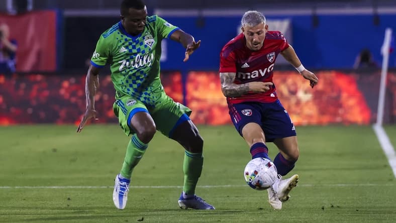 May 7, 2022; Frisco, Texas, USA;  FC Dallas forward Paul Arriola (7) kicks the balll away from Seattle Sounders defender Nouhou Tolo (5) during the first half at Toyota Stadium. Mandatory Credit: Kevin Jairaj-USA TODAY Sports