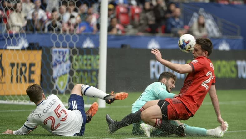 May 8, 2022; Vancouver, British Columbia, CAN; Toronto FC goalkeeper Alex Bono (25) and defender Shane O'Neill (27) defend against Vancouver Whitecaps midfielder Ryan Gauld (25) during the first half at BC Place. Mandatory Credit: Anne-Marie Sorvin-USA TODAY Sports
