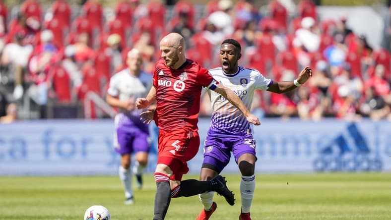 May 14, 2022; Toronto, Ontario, CAN; Toronto FC midfielder Michael Bradley (4) wins the ball off Orlando City midfielder Andr  s Perea (21) during the first half at BMO Field. Mandatory Credit: Kevin Sousa-USA TODAY Sports