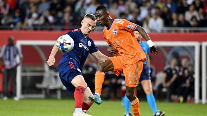 May 14, 2022; Chicago, Illinois, USA; FC Cincinnati defender Gustavo Vallecilla (5) and Chicago Fire defender Boris Sekuli   (2) battle for the ball in the second half at Soldier Field. Mandatory Credit: Jamie Sabau-USA TODAY Sports