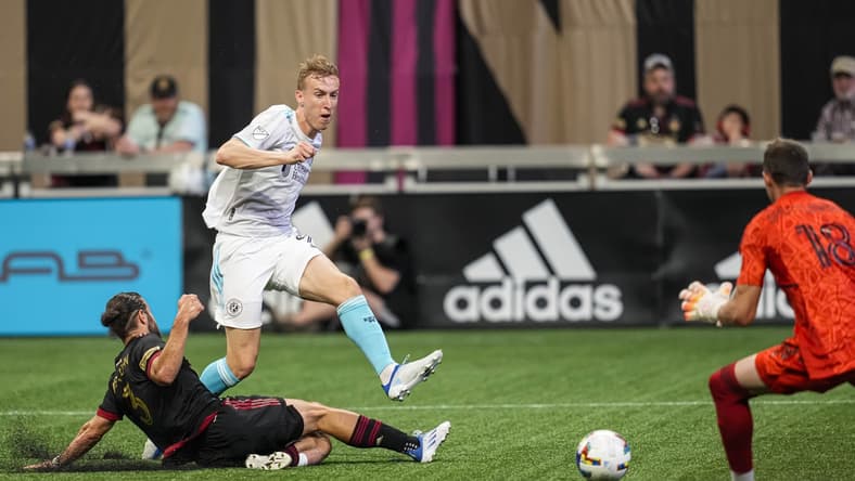 May 15, 2022; Atlanta, Georgia, USA; New England Revolution forward Adam Buksa (9) scores a goal past Atlanta United defender Alex De John (3) and goalkeeper Bobby Shuttleworth (18) during the first half at Mercedes-Benz Stadium. Mandatory Credit: Dale Zanine-USA TODAY Sports