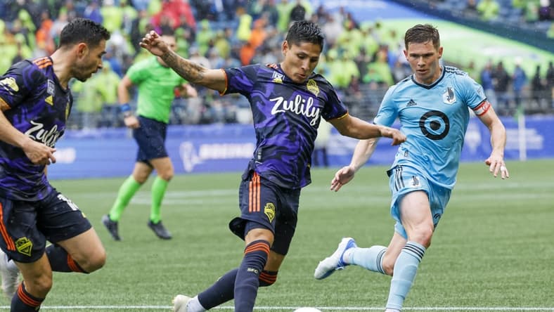 May 15, 2022; Seattle, Washington, USA; Seattle Sounders FC forward Raul Ruidiaz (9) dribbles against Minnesota United FC midfielder Will Trapp (20) during the first half at Lumen Field. Mandatory Credit: Joe Nicholson-USA TODAY Sports