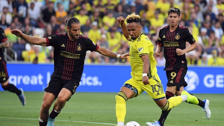 May 11, 2022; Nashville, Tennessee, USA; Nashville SC midfielder Hany Mukhtar (10) works against Atlanta United defender Alex De John (3) during the first half at Geodis Park. Mandatory Credit: Christopher Hanewinckel-USA TODAY Sports