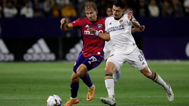 May 14, 2022; Carson, California, USA;  FC Dallas midfielder Paxton Pomykal (19) and Los Angeles Galaxy midfielder Marco Delgado (8) battles for the ball during the second half at Dignity Health Sports Park. Mandatory Credit: Kiyoshi Mio-USA TODAY Sports