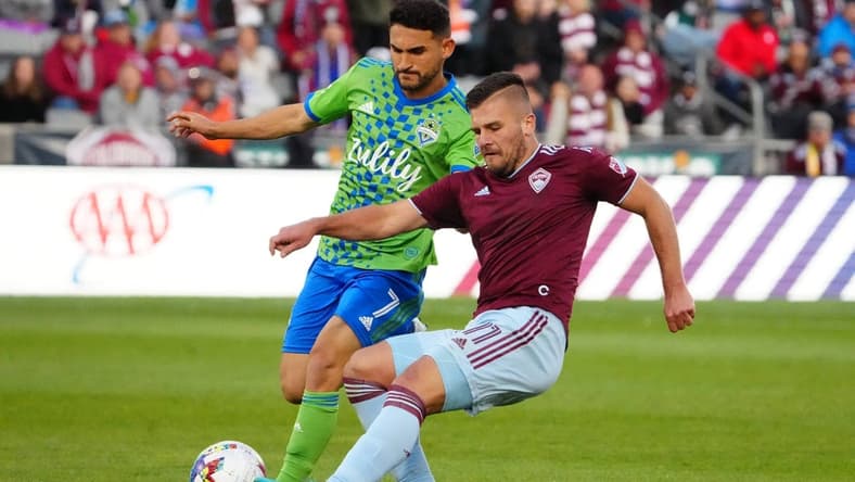 May 22, 2022; Commerce City, Colorado, USA; Colorado Rapids forward Diego Rubio (11) kicks the ball past Seattle Sounders midfielder Cristian Roldan (7) in the second half at Dick's Sporting Goods Park. Mandatory Credit: Ron Chenoy-USA TODAY Sports