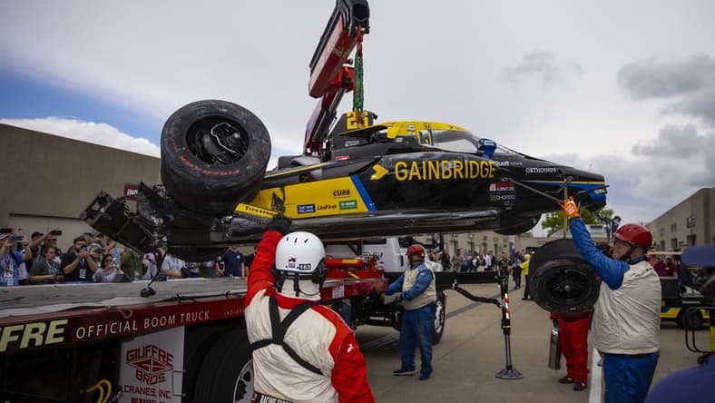 May 27, 2022; Indianapolis, Indiana, USA; The crashed car of IndyCar Series driver Colton Herta is unloaded by a tow truck in the garage area after crashing during Carb Day practice at Indianapolis Motor Speedway. Mandatory Credit: Mark J. Rebilas-USA TODAY Sports
