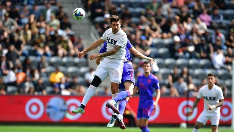 May 28, 2022; Los Angeles, California, USA; Los Angeles FC midfielder Ryan Hollingshead (24) plays for the ball against San Jose Earthquakes midfielder Jan Gregus (17)  during the first half at Banc of California Stadium. Mandatory Credit: Gary A. Vasquez-USA TODAY Sports