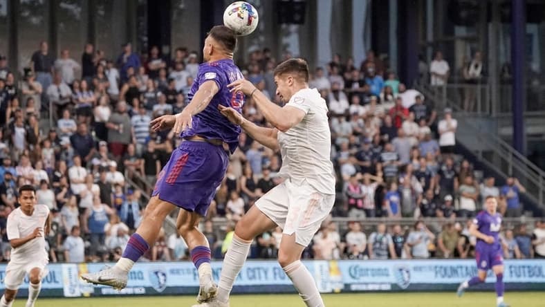 May 28, 2022; Kansas City, Kansas, USA; Vancouver Whitecaps forward Lucas Cavallini (9) heads the ball as Sporting Kansas City defender Andreu Fontas (3) defends during the first half at Children's Mercy Park. Mandatory Credit: Denny Medley-USA TODAY Sports