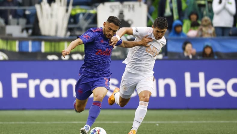 May 29, 2022; Seattle, Washington, USA; Seattle Sounders FC midfielder Cristian Roldan (7) and Charlotte FC defender Joseph Mora (28) pursue an outlet pass during the first half at Lumen Field. Mandatory Credit: Joe Nicholson-USA TODAY Sports