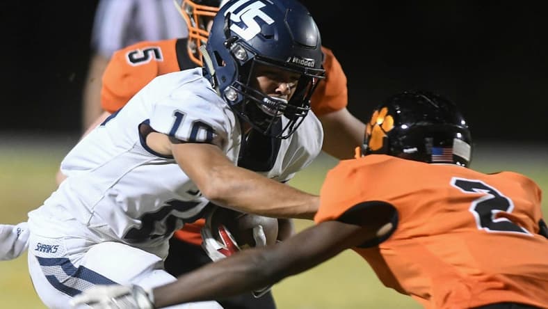 Brandon Inniss of University is brought down by Chavis Thompson (2) and Brock Holland (5) of Cocoa during Friday's Class 4A state semifinal.

High School Football University At Cocoa