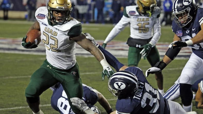 Dec 18, 2021; Shreveport, LA, USA; UAB Blazers running back DeWayne McBride (22) breaks a tackle against the BYU Cougars linebacker Max Tooley (31) during the fourth quarter during the 2021 Independence Bowl at Independence Stadium. Mandatory Credit: Petre Thomas-USA TODAY Sports