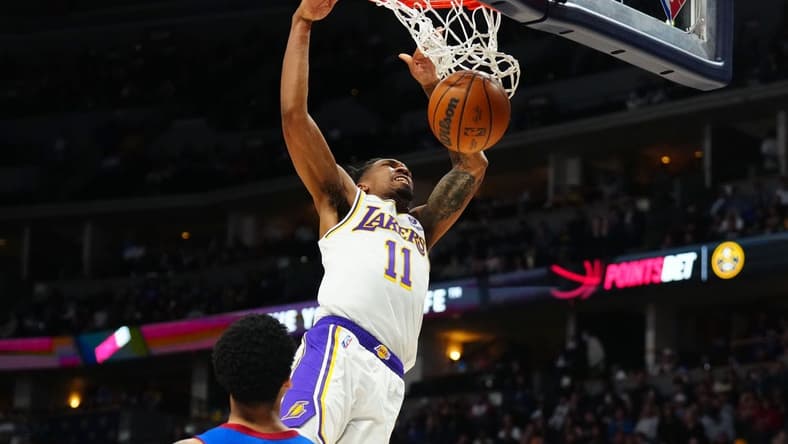 Apr 10, 2022; Denver, Colorado, USA; Los Angeles Lakers guard Malik Monk (11) finishes off a basket in the second half against the Denver Nuggets at Ball Arena. Mandatory Credit: Ron Chenoy-USA TODAY Sports