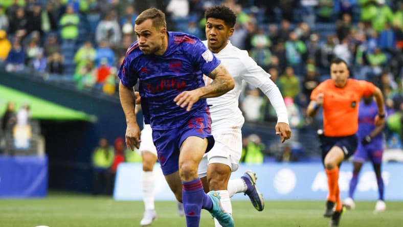 May 29, 2022; Seattle, Washington, USA; Seattle Sounders FC forward Jordan Morris (13) dribbles ahead of Charlotte FC defender Christian Makoun (14) during the first half at Lumen Field. Mandatory Credit: Joe Nicholson-USA TODAY Sports