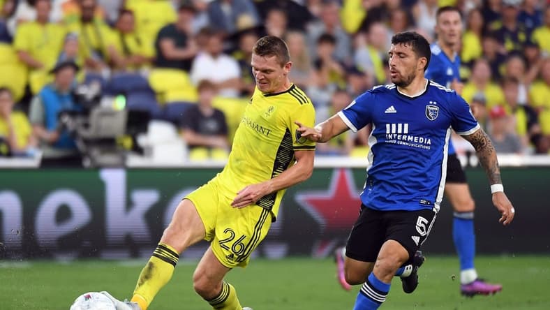 Jun 11, 2022; Nashville, Tennessee, USA; Nashville SC midfielder Luke Haakenson (26) passes the ball against San Jose Earthquakes midfielder Eric Remedi (5) during the first half at Geodis Park. Mandatory Credit: Christopher Hanewinckel-USA TODAY Sports