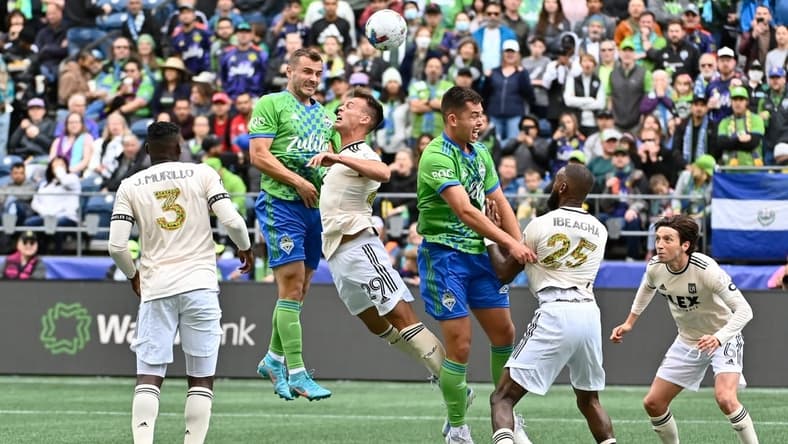 Jun 18, 2022; Seattle, Washington, USA; Seattle Sounders forward Jordan Morris (13) heads the ball over Los Angeles FC forward Danny Musovski (29) during the first half at Lumen Field. Mandatory Credit: Steven Bisig-USA TODAY Sports