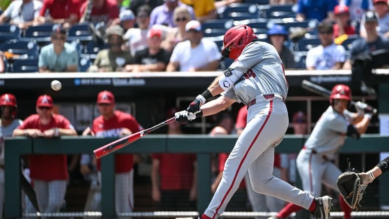 Jun 18, 2022; Omaha, NE, USA; Arkansas Razorbacks right fielder Chris Lanzilli (18) launches a three-run home run in the fifth inning against the Stanford Cardinal at Charles Schwab Field. Mandatory Credit: Steven Branscombe-USA TODAY Sports