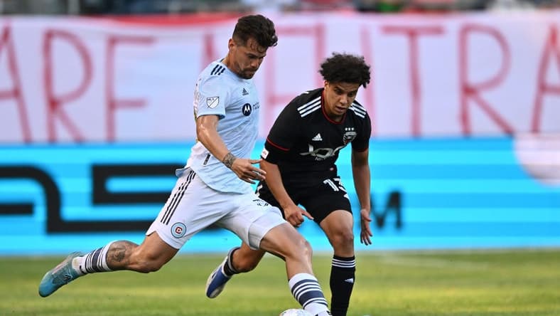 Jun 18, 2022; Chicago, Illinois, USA;  Chicago Fire FC midfielder Gaston Gimenez (30) controls the ball against DC United midfielder Sofiane Djeffal (13) in the first half at Soldier Field. Mandatory Credit: Jamie Sabau-USA TODAY Sports