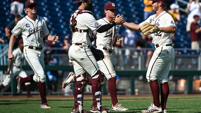 Jun 19, 2022; Omaha, NE, USA;  Texas A&M Aggies pitcher Brad Rudis (32) and catcher Troy Claunch (12) celebrate the win against the Texas Longhorns at Charles Schwab Field. Mandatory Credit: Steven Branscombe-USA TODAY Sports