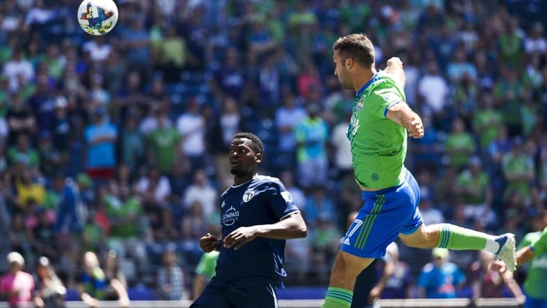 Jun 25, 2022; Seattle, Washington, USA; Seattle Sounders FC forward Will Bruin (17) scores a goal on a header against Sporting Kansas City defender Nicolas Isimat-Mirin (5) during the first half at Lumen Field. Mandatory Credit: Joe Nicholson-USA TODAY Sports
