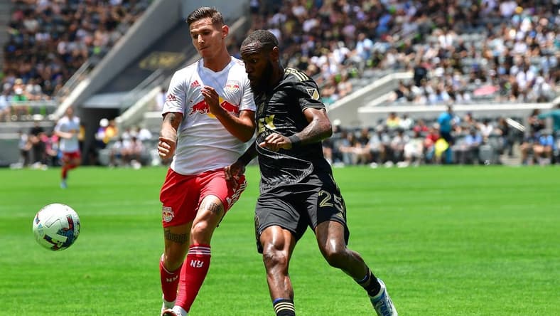 Jun 26, 2022; Los Angeles, California, USA; Los Angeles FC defender Sebastien Ibeagha (25) plays for the ball against New York Red Bulls forward Patryk Klimala (9) during the first half at Banc of California Stadium. Mandatory Credit: Gary A. Vasquez-USA TODAY Sports