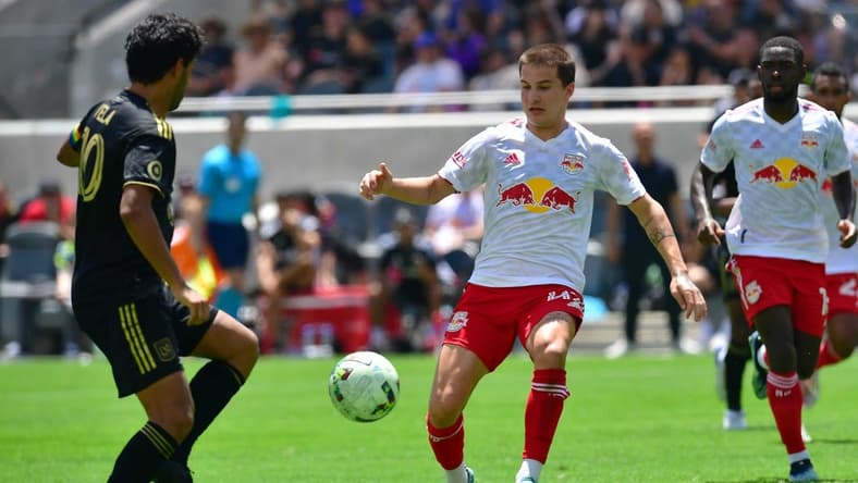 Jun 26, 2022; Los Angeles, California, USA; New York Red Bulls defender John Tolkin (47) plays for the ball against Los Angeles FC forward Carlos Vela (10) during the second half at Banc of California Stadium. Mandatory Credit: Gary A. Vasquez-USA TODAY Sports