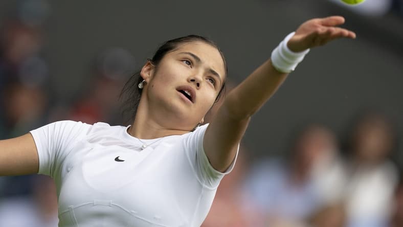 Jun 27, 2022; London, United Kingdom;  Emma Raducanu (GBR) tosses the ball to serve during her first round match against Alison Van Uytvanck (BEL) on day one at All England Lawn Tennis and Croquet Club. Mandatory Credit: Susan Mullane-USA TODAY Sports