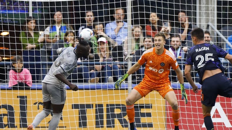 Jun 29, 2022; Seattle, Washington, USA; CF Montreal forward Kei Kamara (23) heads away the ball against the Seattle Sounders FC during the first half at Lumen Field. CF Montreal goalkeeper Sebastian Breza (1) watches the play. Mandatory Credit: Joe Nicholson-USA TODAY Sports
