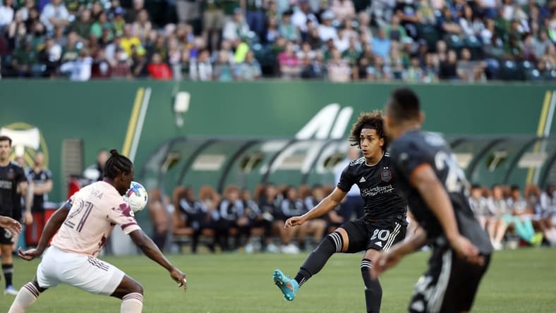 Jun 29, 2022; Portland, Oregon, USA; Houston Dynamo midfielder Adalberto Carrasquilla (20) takes a shot on goal against Portland Timbers midfielder Diego Chara (21) during the first half at Providence Park. Mandatory Credit: Soobum Im-USA TODAY Sports