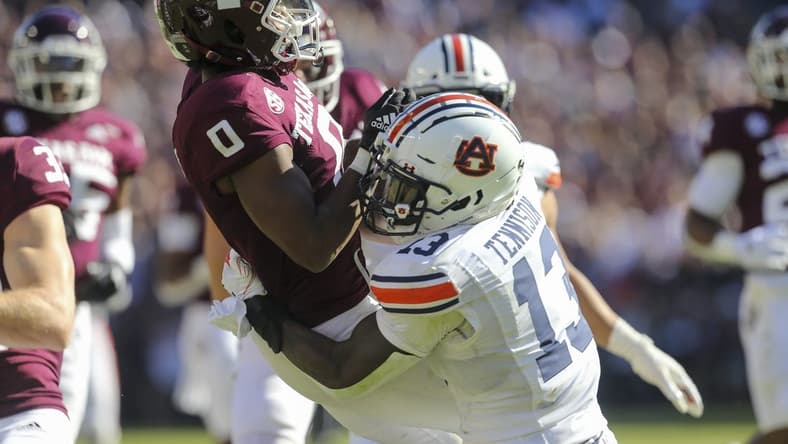 Nov 6, 2021; College Station, Texas, USA; Texas A&M Aggies wide receiver Ainias Smith (0) calls for a fair catch then is tackled by Auburn Tigers safety Ladarius Tennison (13) in the second quarter at Kyle Field. The Tigers were called for a penalty on the play. Mandatory Credit: Thomas Shea-USA TODAY Sports