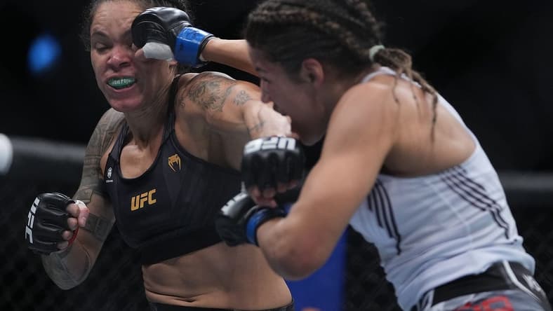 Dec 11, 2021; Las Vegas, Nevada, USA; Julianna Pena moves in with a hit against Amanda Nunes during UFC 269 at T-Mobile Arena. Mandatory Credit: Stephen R. Sylvanie-USA TODAY Sports