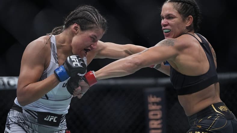 Dec 11, 2021; Las Vegas, Nevada, USA; Amanda Nunes moves in with a hit against Julianna Pena during UFC 269 at T-Mobile Arena. Mandatory Credit: Stephen R. Sylvanie-USA TODAY Sports