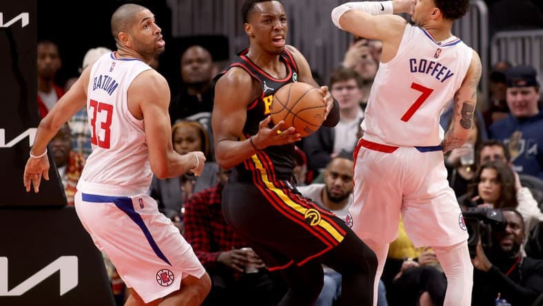 Mar 11, 2022; Atlanta, Georgia, USA; Atlanta Hawks forward Onyeka Okongwu (17) grabs a rebound against LA Clippers forward Nicolas Batum (33) and guard Amir Coffey (7) during the second half at State Farm Arena. Mandatory Credit: Jason Getz-USA TODAY Sports