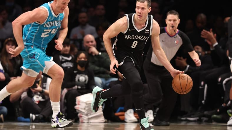 Mar 27, 2022; Brooklyn, New York, USA; Brooklyn Nets guard Goran Dragic (9) dribbles up court in front of Charlotte Hornets center Mason Plumlee (24) during the second half at Barclays Center. Mandatory Credit: Vincent Carchietta-USA TODAY Sports