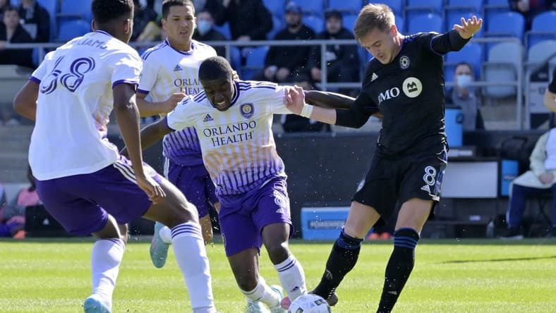 May 7, 2022; Montreal, Quebec, CAN; CF Montreal midfielder Djordje Mihailovic (right) controls the ball against Orlando City SC midfielder Jhegson Sebastian Mendez (middle) during the first half at Stade Saputo. Mandatory Credit: Eric Bolte-USA TODAY Sports