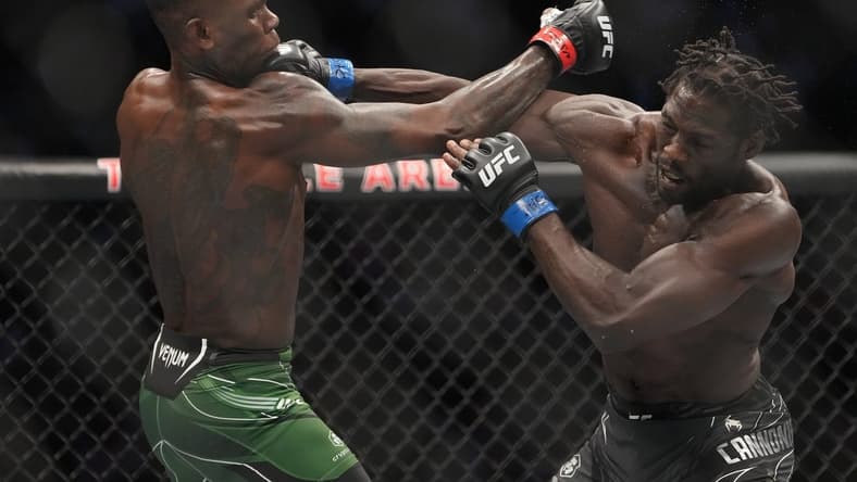 Jul 2, 2022; Las Vegas, Nevada, USA; Israel Adesanya (red gloves) and Jared Cannonier (blue gloves) fight in a bout during UFC 276 at T-Mobile Arena. Mandatory Credit: Stephen R. Sylvanie-USA TODAY Sports