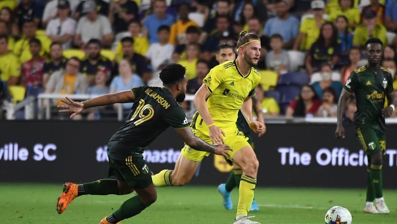Jul 3, 2022; Nashville, Tennessee, USA; Nashville SC defender Walker Zimmerman (25) plays the ball against Portland Timbers midfielder Eryk Williamson (19) during the second half at Geodis Park. Mandatory Credit: Christopher Hanewinckel-USA TODAY Sports