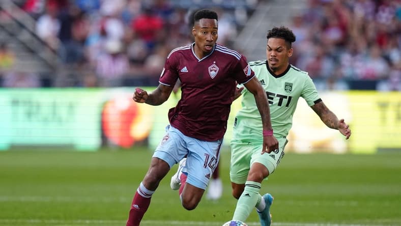 Jul 4, 2022; Commerce City, Colorado, USA; Colorado Rapids midfielder Mark-Anthony Kaye (14) drives past Austin FC midfielder Daniel Pereira (6) in the first half at Dick's Sporting Goods Park. Mandatory Credit: Ron Chenoy-USA TODAY Sports
