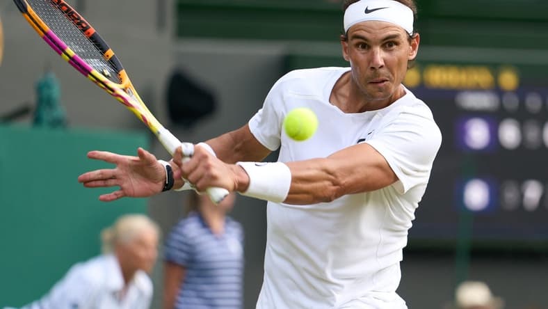 Jul 6, 2022; London, England, United Kingdom; Rafael Nadal (ESP) returns a shot during his quarter finals men   s singles match against Taylor Fritz (USA) on Centre court at All England Lawn Tennis and Croquet Club. Mandatory Credit: Peter van den Berg-USA TODAY Sports